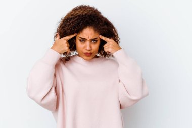 Beyaz arka planda izole edilmiş genç Afrikalı Amerikalı kadın bir göreve odaklanmış, işaret parmaklarını işaret ediyor..