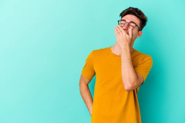 Kafkasyalı genç adam mavi arka planda yalnızdı gülerek, kaygısızca, doğal duygularla.