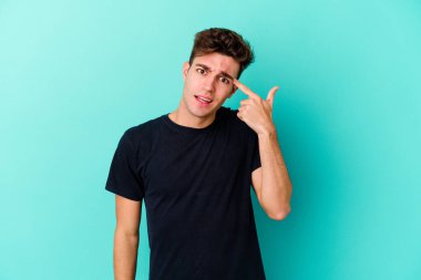 Renkli arka planda poz veren beyaz bir genç. 