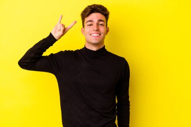 Renkli arka planda poz veren beyaz bir genç. 