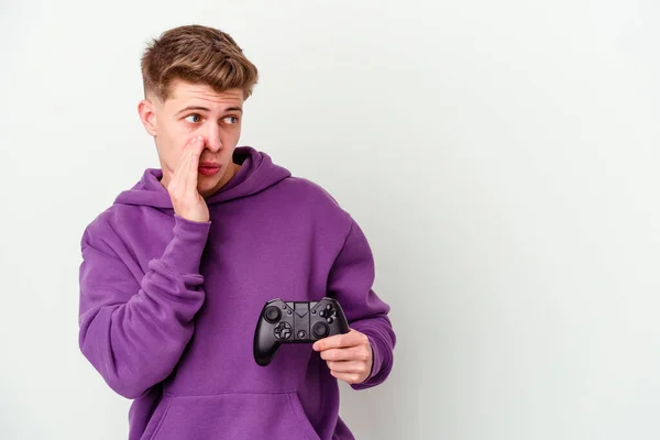 Jovem Caucasiano Segurando Gamepad Isolado Fundo Branco Está Dizendo Segredo — Fotografia de Stock