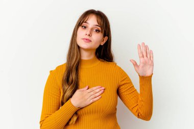 Beyaz arka planda izole edilmiş beyaz tenli hoş bir kadın yemin ediyor, elini göğsüne koyuyor..