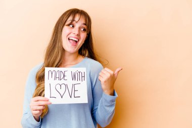 Elinde aşk levhası olan beyaz bir kadın parmak arası izole edilmiş, gülen ve kaygısız noktalar tutuyor..