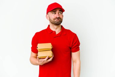 Beyaz arka planda izole edilmiş beyaz bir teslimatçı kafası karışmış, şüpheli ve güvensiz hissediyor..