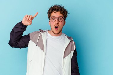 Mavi arka planda izole edilmiş gözlüklü genç bir beyaz adamın harika bir fikri var, yaratıcılık kavramı..