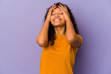 Genç Afrikalı Afro-Amerikan kadın yalnız kahkahalar atarak ellerini başının üstünde tutuyor. Mutluluk kavramı.