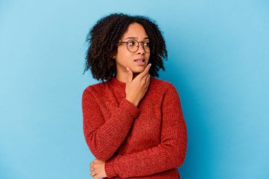 Genç Afro-Amerikan melez kadın kafasının arkasına dokunuyor, düşünüyor ve bir seçim yapıyor..