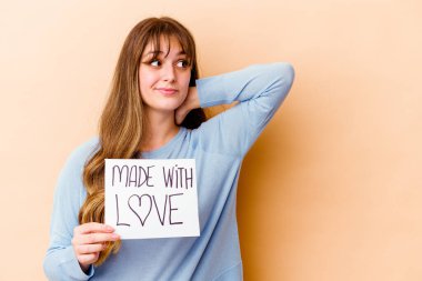 Kafkasyalı genç bir kadın aşk levhasını tutuyor. Kafasının arkasına dokunuyor, düşünüyor ve bir seçim yapıyor..