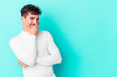 Kafkasyalı genç adam mavi arka planda yalnızdı gülerek, kaygısızca, doğal duygularla.