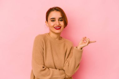 Genç Arap melez kadın işaret parmağıyla işaret ederek gülümsüyor..