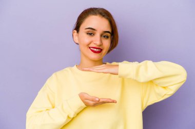 Genç Arap melez kadın iki eliyle bir şey tutuyor, ürün sunumu..