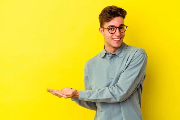 Νεαρός Καυκάσιος Άνδρας Απομονωμένος Κίτρινο Φόντο Κρατώντας Ένα Αντίγραφο Χώρου — Φωτογραφία Αρχείου
