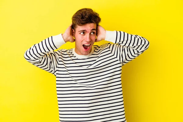 Sarı arka planda izole edilmiş genç beyaz bir adam çığlık atıyor, çok heyecanlı, tutkulu, bir şeyden memnun..
