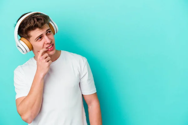 Giovane Uomo Caucasico Ascoltare Musica Con Cuffie Isolate Sfondo Blu — Foto Stock