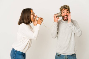 Latin kökenli genç arkadaşlar konserve kutusundan bağırarak ve avuç içini açarak konuşuyorlar..