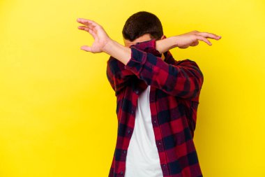 Sarı arka planda izole genç beyaz adam iki kolu çapraz tutuyor, inkar kavramı.