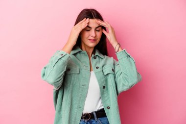 Genç beyaz kadın pembe arka planda izole edilmiş tapınaklara dokunuyor ve baş ağrısı çekiyor..