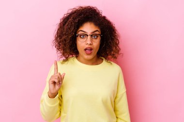 Genç Afrikalı Amerikalı kadın pembe arka planda izole edilmiş. Bir fikri var, ilham verici bir kavram..