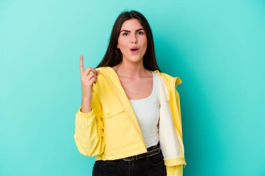 Kafkasyalı genç bir kadın mavi arka planda izole edilmiş. Bir fikri var, ilham verici bir kavram..