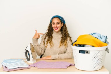 Giysileri ütüleyen beyaz bir kadın gömlek fotokopisini elle gösteren, gururlu ve kendinden emin birini gösterdi.