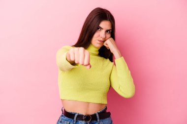 Pembe arka planda izole edilmiş genç beyaz kadın bir tartışma yüzünden yumruk, öfke, kavga ve boks atıyor..