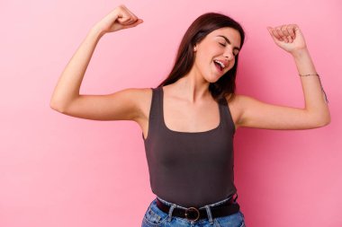 Pembe arka planda izole edilmiş beyaz bir kadın zaferden sonra yumruğunu kaldırıyor, kazanan konsept.