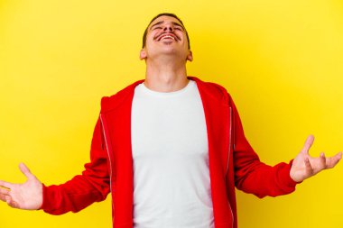 Sarı arka planda izole edilmiş, rahat ve mutlu bir şekilde gülen, boynunu uzatmış, dişlerini gösteren beyaz bir adam..