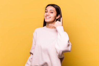 Sarı arka planda izole edilmiş genç Hintli kadın parmakları olan bir cep telefonu hareketi gösteriyor..