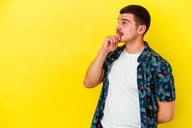 Sarı arka planda izole edilmiş beyaz bir adam rahatlamış bir şeyin fotokopi odasına baktığını düşünüyor..