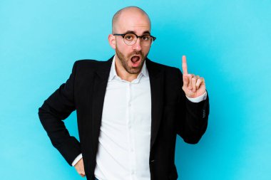 Genç, beyaz, kel bir adam mavi arka planda izole edilmiş. Bir fikri var, ilham verici bir kavram..