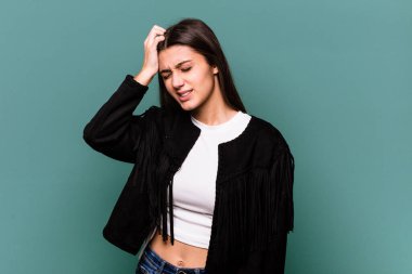 Genç Hintli kadın mavi arka planda izole edilmiş zafer, tutku ve coşkuyu kutluyor, mutlu bir ifade..