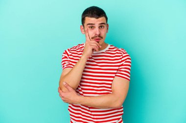 Kafkasyalı genç adam mavi arka planda izole edildi. Harika bir fikri var, yaratıcılık kavramı..