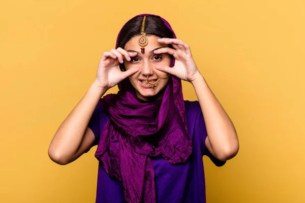 若いですインド人女性を身に着けています伝統的なサリーの服黄色の背景に隔離されました目を開いて成功の機会を見つけるために — ストック写真