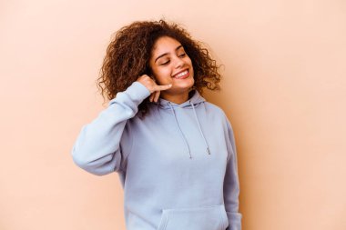 Bej arka planda izole edilmiş genç Afrikalı Amerikalı kadın parmakları olan bir cep telefonu hareketi gösteriyor..