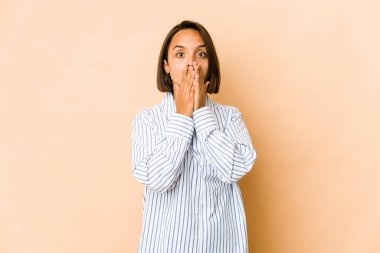 Genç İspanyol kadın bir şeye gülüyor, elleriyle ağzını kapatıyor..