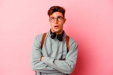 Pembe arka planda izole edilmiş genç bir öğrenci tekrarlanan bir görevden yoruldu..