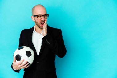 Beyaz arka planda izole edilmiş genç beyaz futbol antrenörü gizli bir sıcak fren haberi veriyor ve kenara bakıyor.