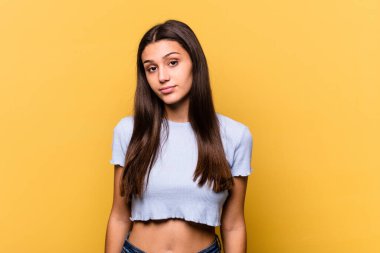 Genç Hintli kadın sarı arka planda izole edilmiş üzgün, ciddi yüzlü, mutsuz ve hoşnutsuz..