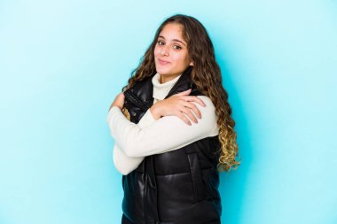 Genç, beyaz, kıvırcık saçlı kadın sarılıyor, kaygısızca gülümsüyor ve mutlu..