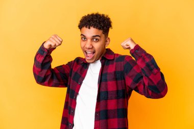 Genç Afro-Amerikan kıvırcık adamı mor bir tezahürat yapıyor ve heyecanlanıyor. Zafer konsepti.