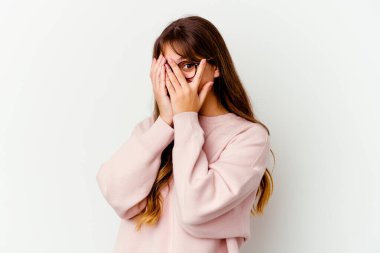 Beyaz arka planda izole edilmiş beyaz tenli, genç beyaz bir kadın parmaklarıyla gözünü kırp korkmuş ve gergin..