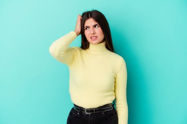 Mavi arka planda izole edilmiş genç beyaz kadın zaferi, tutkuyu ve coşkuyu kutluyor, mutlu bir ifade..