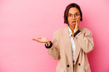 Pembe arka planda izole edilmiş genç iş kadını avuç içi fotokopi alanını elinde tutmaktan etkilenmiş..