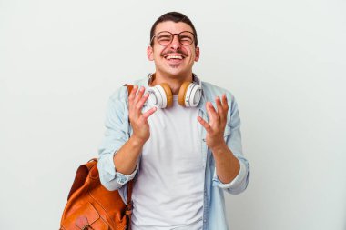 Beyaz arka planda izole edilmiş müzik dinleyen beyaz bir öğrenci neşeli neşeli gülüyor. Mutluluk kavramı.