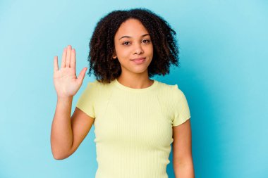 Genç Afro-Amerikan melez kadın tebessüm ederek beş numarayı parmaklarıyla gösterdi..