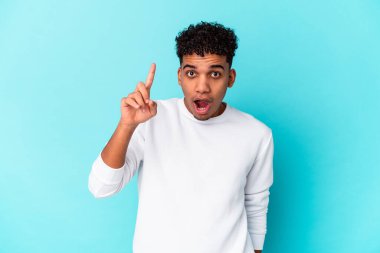 Genç Afro-Amerikan kıvırcık adamı mavi üzerine izole edilmiş bir fikir, ilham konsepti.