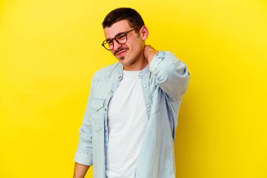 Kafkas asıllı genç adam sarı arka planda izole edilmiş sabit yaşam tarzından dolayı boyun ağrısı çekiyor..