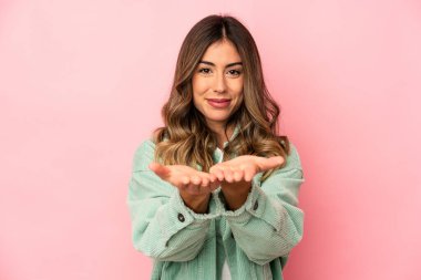 Kafkasyalı genç bir kadın avuçlarıyla bir şey tutarak kameraya sunuyor..