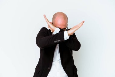 Genç beyaz tenli kel adam mavi arka planda izole edilmiş iki kolu çapraz tutuyor, inkar kavramı..