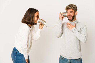 Latin kökenli genç arkadaşlar teneke kutu sisteminden konuşuyorlar kahkahalar atıyorlar ellerini göğsüne koyuyorlar..